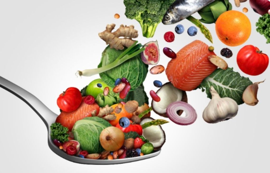 Cuillère remplie d'aliments anti-inflammatoires: légumes, poissons gras, épices et graines bénéfiques pour le sommeil