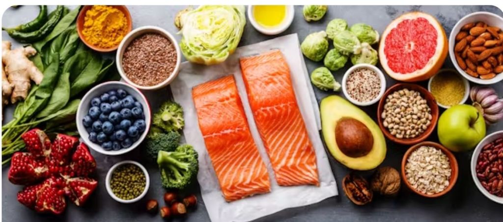 Assiette blanche avec deux pavés de saumon entourés d'aliments anti-inflammatoires comme avocat, choux, brocolis, épices, noisettes, illustrant une alimentation santé