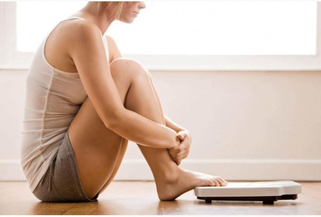 Femme de plus de 40 ans assise, réflexion sur son poids à la ménopause