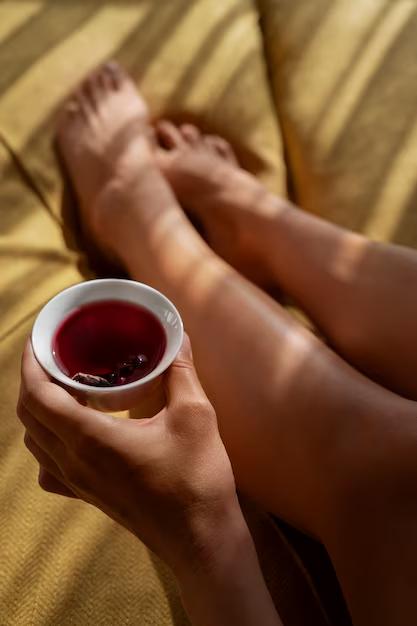 Femme détendue tenant une tisane relaxante du soir pour mieux dormir à la ménopause